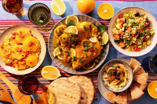 Moroccan feast with chicken tagine, vegetable couscous, orange salad, and eggplant dip