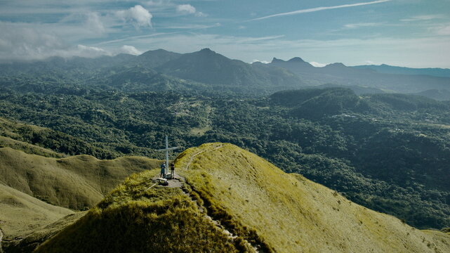 Aerial view of Cerro Gaital's cross standing tall against the backdrop of rolling hills and distant mountains under a vast sky, El Valle de Ant&Atilde;&sup3;n, Cocl&Atilde;&copy; Province, Panama.