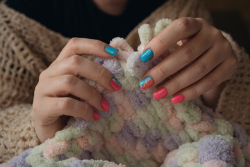 Close up fingers making blanket from yarn without crochet hook or knitting needles