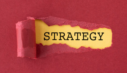 A torn piece of paper with the word Strategy written on it