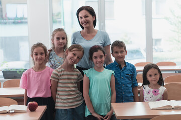 Obraz premium Portrait of children in a preschool institution with their teacher in a torn classroom. Selective focus