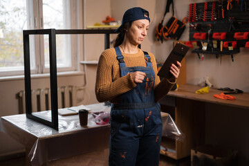 Woman repairman, craftsman or mechanic wearing overalls search for material, deal and discount on web using digital tablet in garage workshop