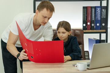 Adult male explaining red binder contents to child
