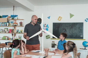 Elementary School Stem Robotics Classroom Diverse Group of Children Building and Programming windmill ecology robot concept. Together Talking and Working as a Team. Creative Robotics Engineering