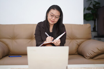 Woman Taking Notes During Online Meeting