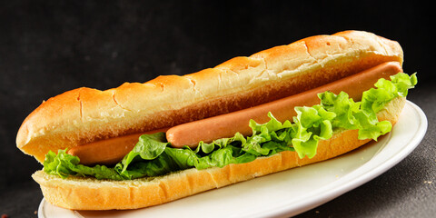 Hot dog fresh bun, sausage, green lettuce leaf homemade sandwich tasty snack fresh delicious gourmet food background on the table rustic food top view copy space
