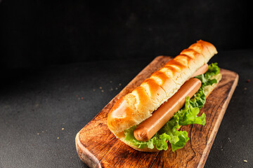 Hot dog fresh bun, sausage, green lettuce leaf homemade sandwich tasty snack fresh delicious gourmet food background on the table rustic food top view copy space