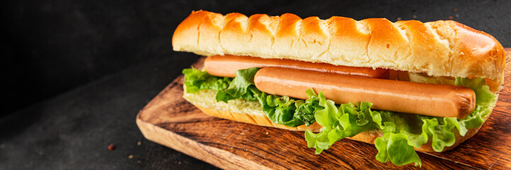 Hot dog fresh bun, sausage, green lettuce leaf homemade sandwich tasty snack fresh delicious gourmet food background on the table rustic food top view copy space