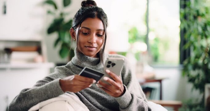 Credit card, online shopping and phone with woman on sofa in living room of home for checkout. App, ecommerce and payment with happy Indian girl in apartment for purchase, transfer or transaction