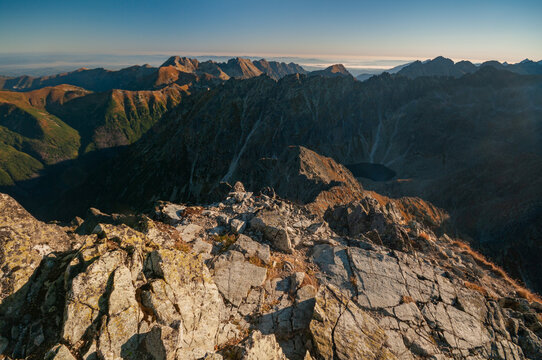 Aerial view of rugged peaks and shadowed valleys create a striking tapestry of light and dark in the mountainous landscape, Vysoke Tatry, Presov Region, Slovakia.