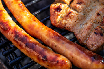 Pork chops, steak, sausages on barbecue grill