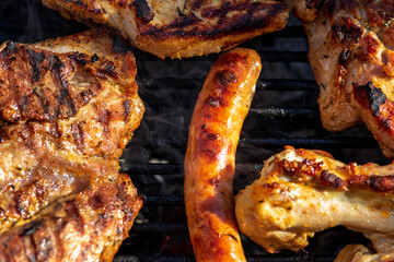 Pork chops, steak, sausages on barbecue grill