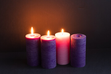 Three advent candles lit in a dark room with copy space