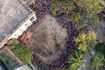 Aerial view of a vibrant crowd gathers in a square outlined by trees and buildings, creating a lively scene of color and movement, Dhaka, Dhaka Division, Bangladesh.
