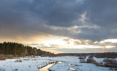 Snowy landscape with a river running through it