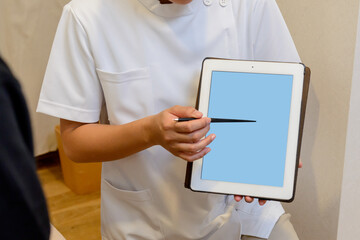 タブレット画面を指し示す医療スタッフの手元