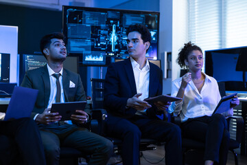 Diverse high performing team of data analysts and IT professionals collaborating in a control room. innovation, global business strategy, cybersecurity, and financial technology growth