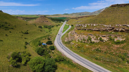 a winding road in the Caucasus, in a gorge surrounded by rocks