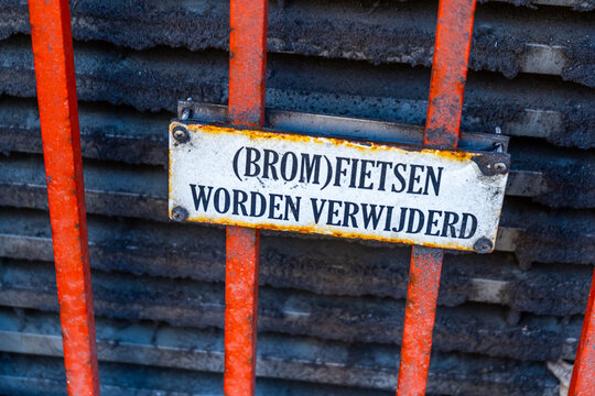 Dutch language Warning sign - Mopeds will be removed - translation. Bicycle parking prohibited. Old metal sign. Amsterdam street Netherlands