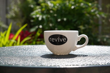 cup of coffee garden patio table. revive caffeine hot beverage 