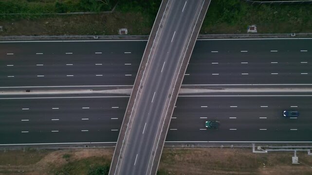 An aerial view of a highway with an overpass and a few cars.