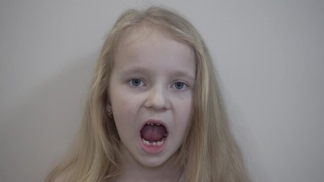 little blonde girl is missing several lower front teeth, baby teeth falling out, little girl missing several front teeth