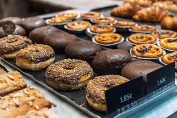 Bakery Display Case with Chocolate Donuts and Portuguese Egg Tarts