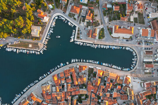 Aerial view of boats docked in the harbor, casting long shadows on the water, contrasting with the terracotta rooftops of the old town, Stari Grad, Split-Dalmatia County, Croatia.