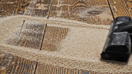 A closeup shot of a modern vacuum cleaner head efficiently removing a scattered pile of small grains or dirt from a rustic wooden floor showcasing effective household cleaning and maintenance for a t.