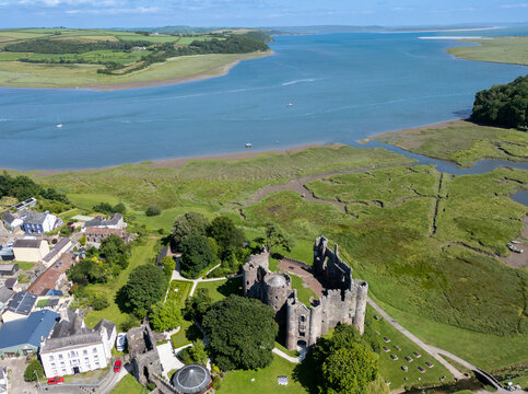 Aerial view of Laugharne Castle ruins standing proudly amidst the lush green landscape where the Taf and Corran rivers meet, Laugherne, Carmarthen, Wales.