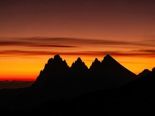 Dramatic mountain silhouette against vibrant sunset sky for adventure