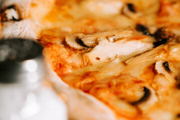 Delicious pizza topped with cheese, chicken, and mushrooms served at a local restaurant