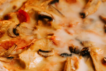 Freshly baked pizza topped with cheese, chicken, and mushrooms served hot from the oven