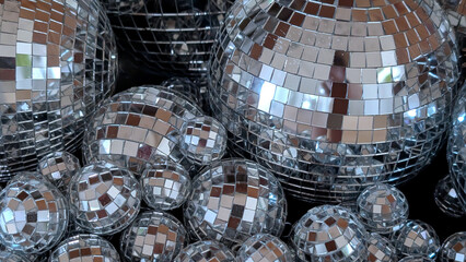 Shimmering disco balls arranged in various sizes, reflecting light and creating a dazzling visual effect