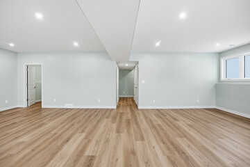 Large, empty room with a white wall and wooden floors