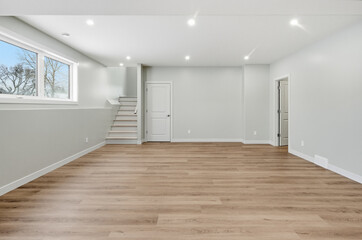 Obraz premium Large, empty room with a wooden floor and white walls