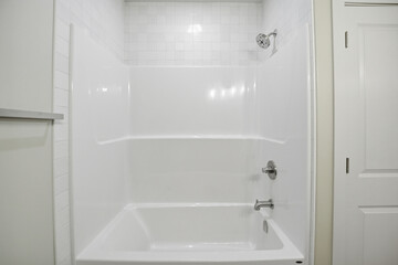 White bathroom with a white bathtub and a white shower