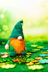St Patrick soft figure over grass and golden and green coins. Background is blurred and green.