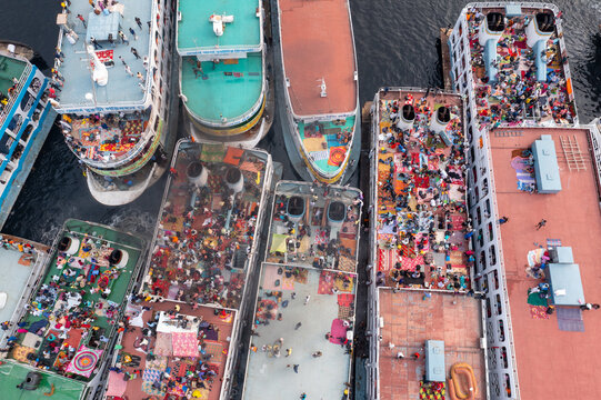 Aerial view of ferries packed with people, their colorful clothing a vibrant tapestry against the muted tones of the vessels, Dhaka, Dhaka Division, Bangladesh.