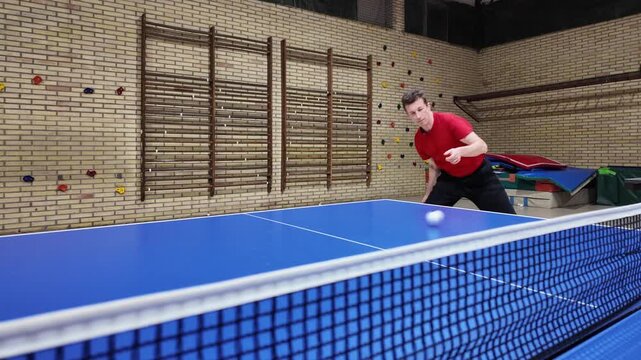 A professional player does a forehand top-spin during training on a blue table, table tennis