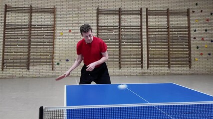 A professional table tennis player makes a forehand shot during practice on a blue table, table tennis, slow motion - Powered by Adobe