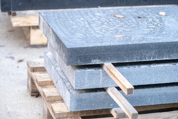 three sawn black granite slabs