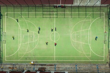 Aerial view of a vibrant green futsal court where players in colorful jerseys engage in a lively match, Lisbon, Lisbon, Portugal.