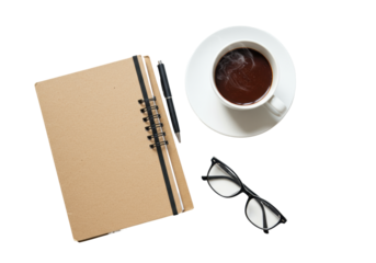 overhead flat lay of a rustic brown spiral notebook, black reading glasses, and steaming hot chocolate mug, knolling style on a brilliant white surface with abundant copy space. cozy remote work and