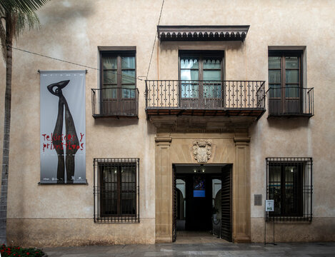 Museo Carmen Thyssen exterior, Renaissance-style palace. Malaga, Spain, wrought iron balconies, large exhibition banner. Historic building entrance.