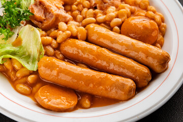 Casule meat with beans in sauce sausages, pork main course tasty snack fresh delicious gourmet food table background rustic food top view copy space