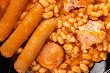 Casule meat with beans in sauce sausages, pork main course tasty snack fresh delicious gourmet food table background rustic food top view copy space