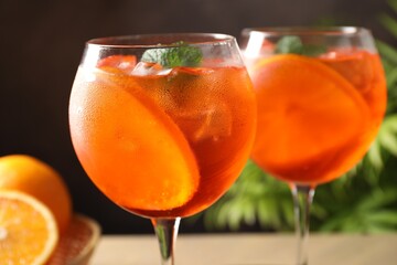 Refreshing spritzer cocktail with mint and oranges on table, closeup