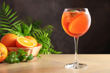 Refreshing spritzer cocktail with mint and oranges on wooden table