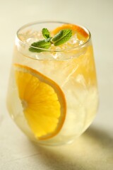 Refreshing spritzer cocktail with mint on light table, closeup